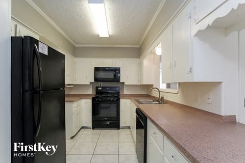a kitchen with a counter top and a black refrigerator