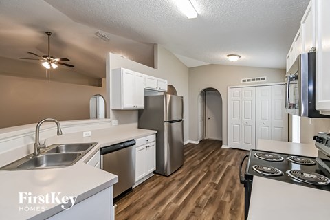 a kitchen with white cabinets and a stainless steel refrigerator