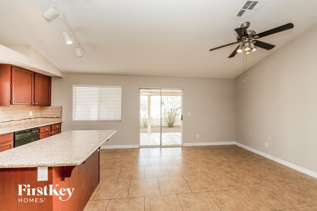 an empty kitchen and living room with a ceiling fan