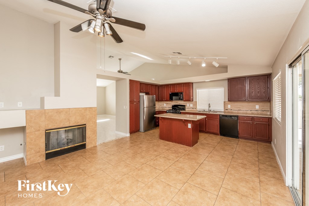 a large kitchen with a fireplace and wooden cabinets