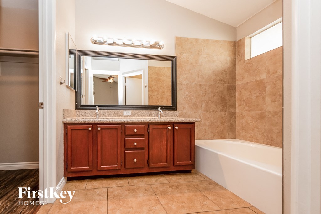 a bathroom with a sink and a tub and a mirror