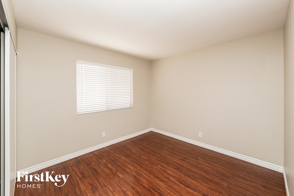an empty room with wood floors and a window