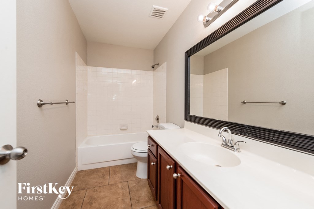 a bathroom with a large mirror and a sink and a toilet