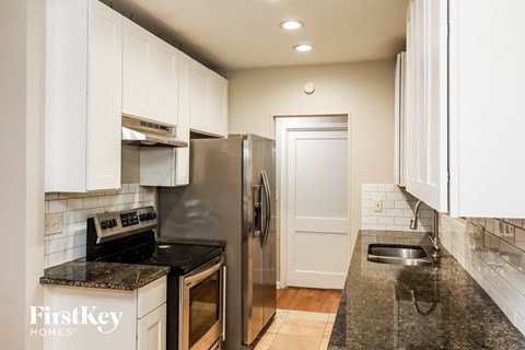a kitchen with white cabinets and a stainless steel refrigerator