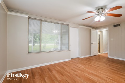 a living room with a ceiling fan and a large window