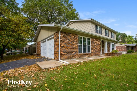 a brick house with a white garage door and a lawn