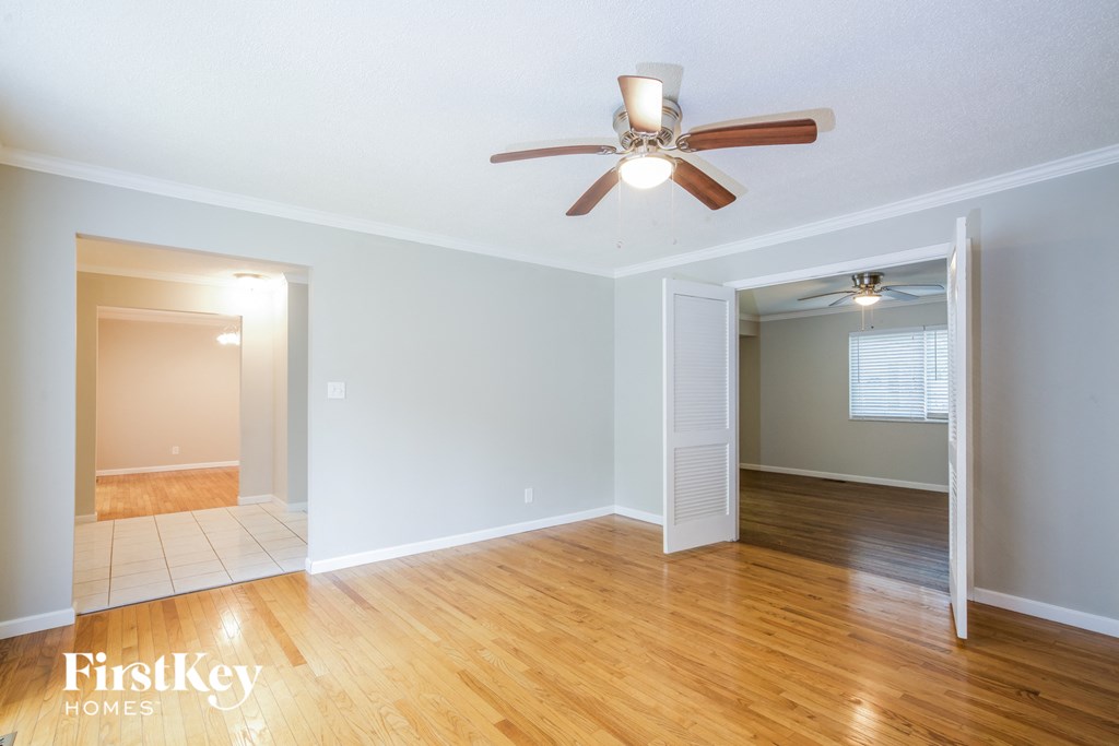 a living room with wood floors and a ceiling fan