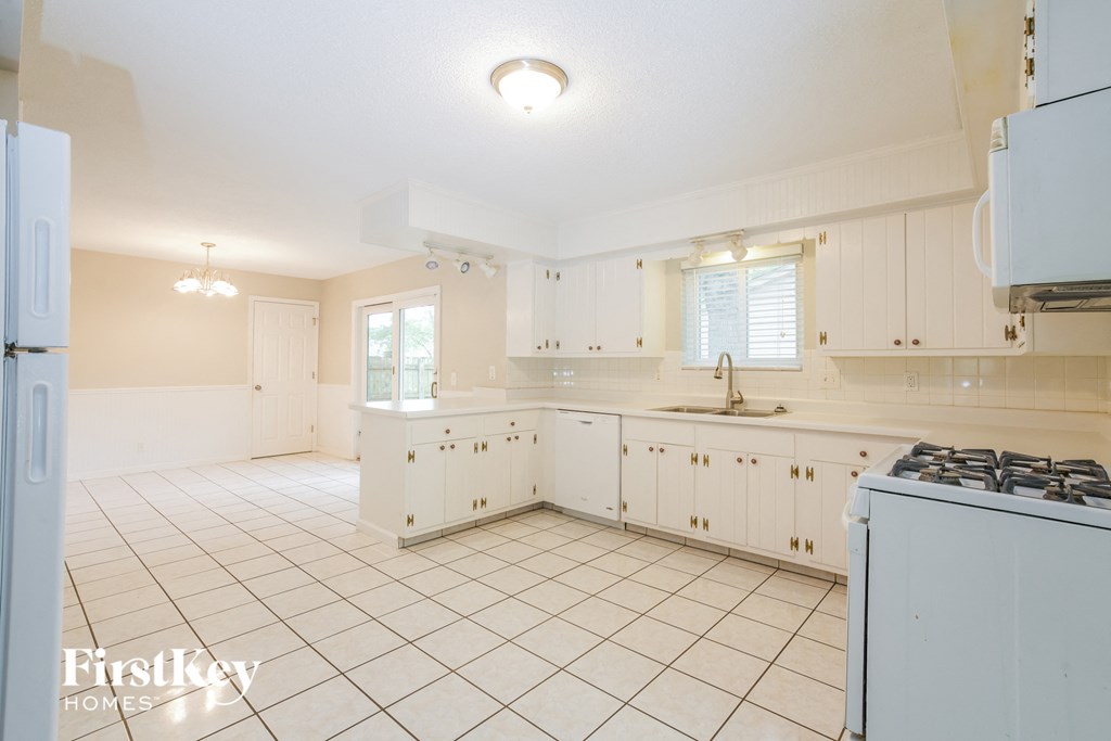 a kitchen with white cabinets and a white tiled floor