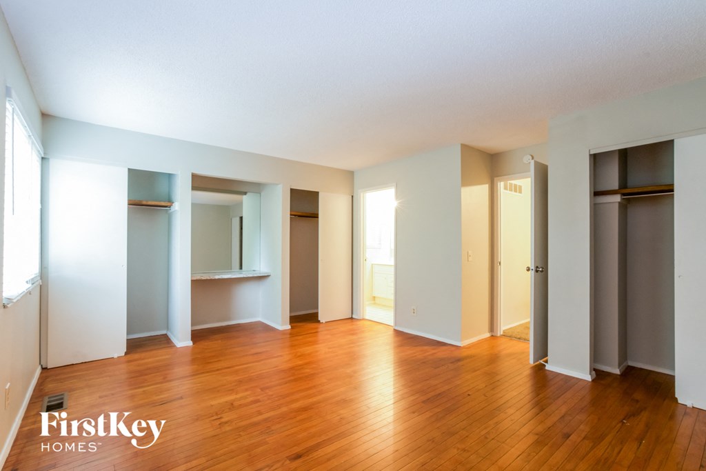 an empty living room with wood floors and blue walls