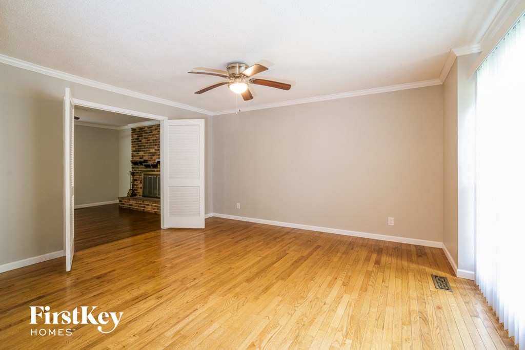 a living room with wood floors and a ceiling fan