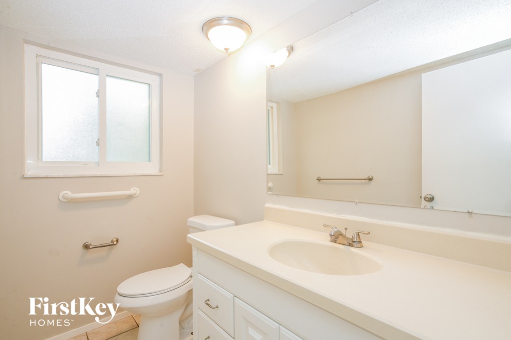 a bathroom with a sink toilet and a mirror
