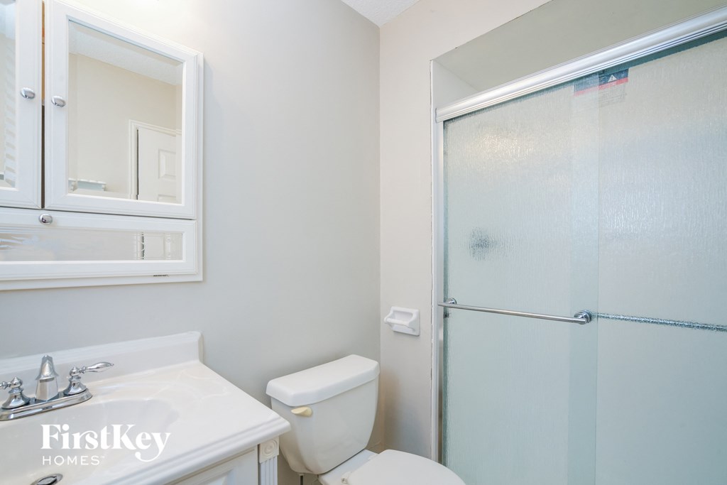 a bathroom with a shower and a sink and a toilet