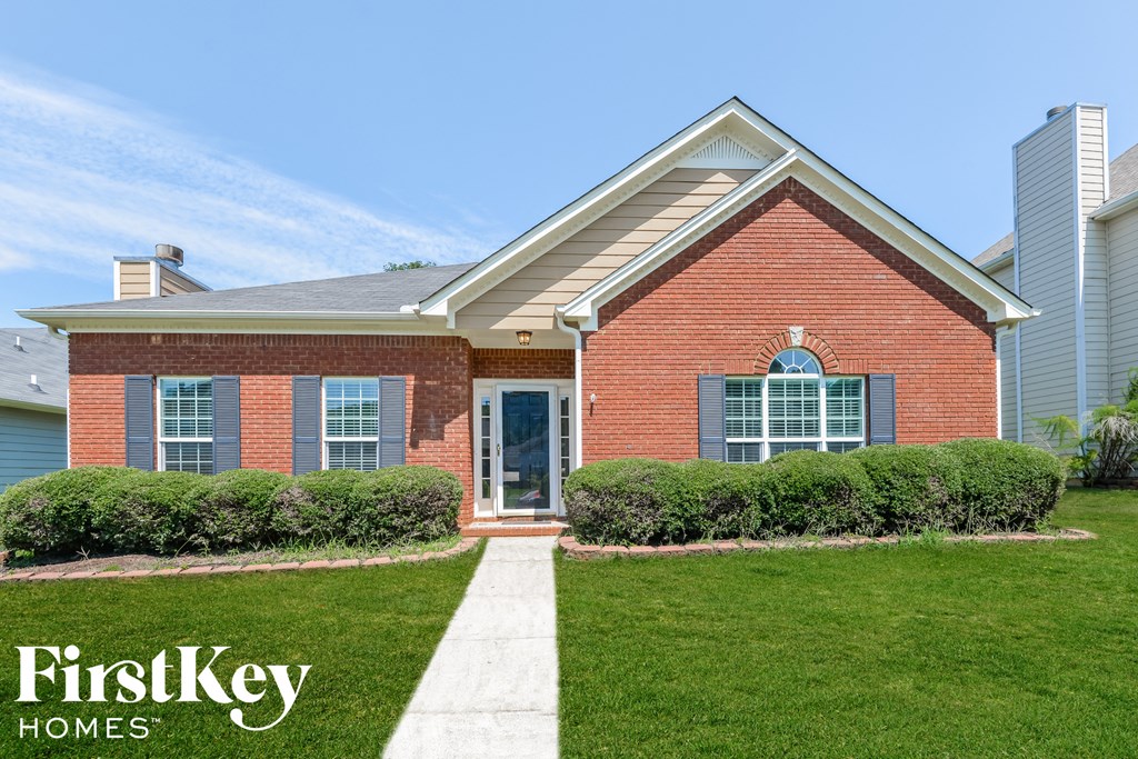 a brick house with a lawn in front of it