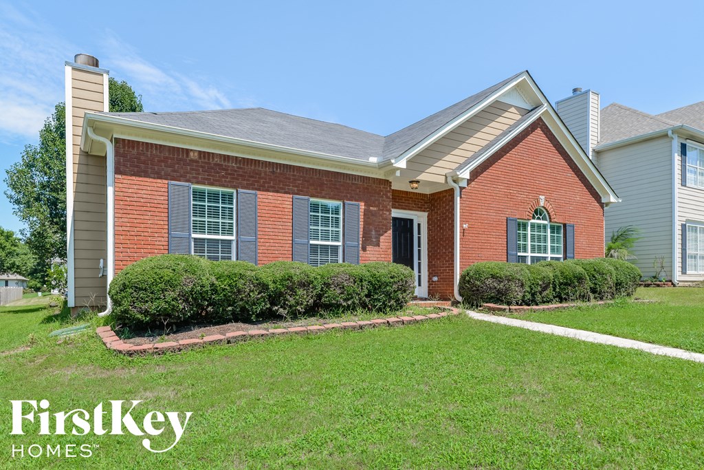 a brick house with a lawn in front of it