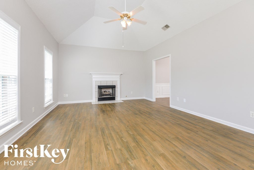 the living room with hardwood floors and a fireplace