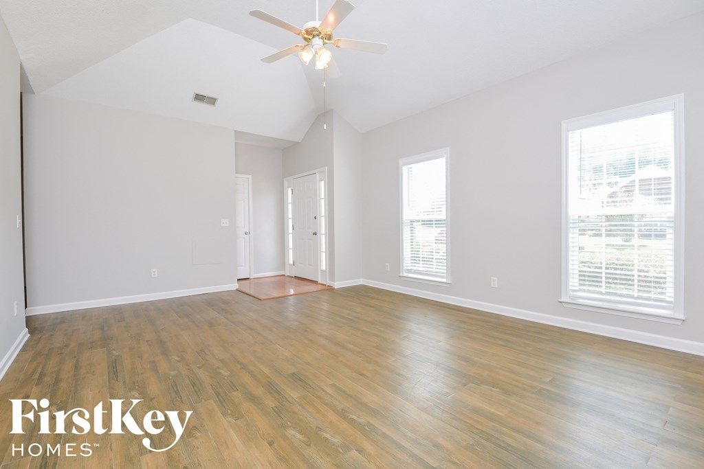 a living room with wood floors and a ceiling fan