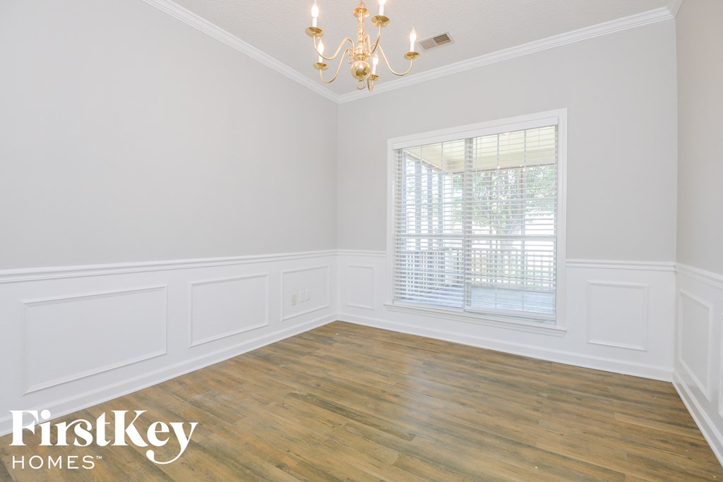 the second bedroom after renovation with wood floors and white walls
