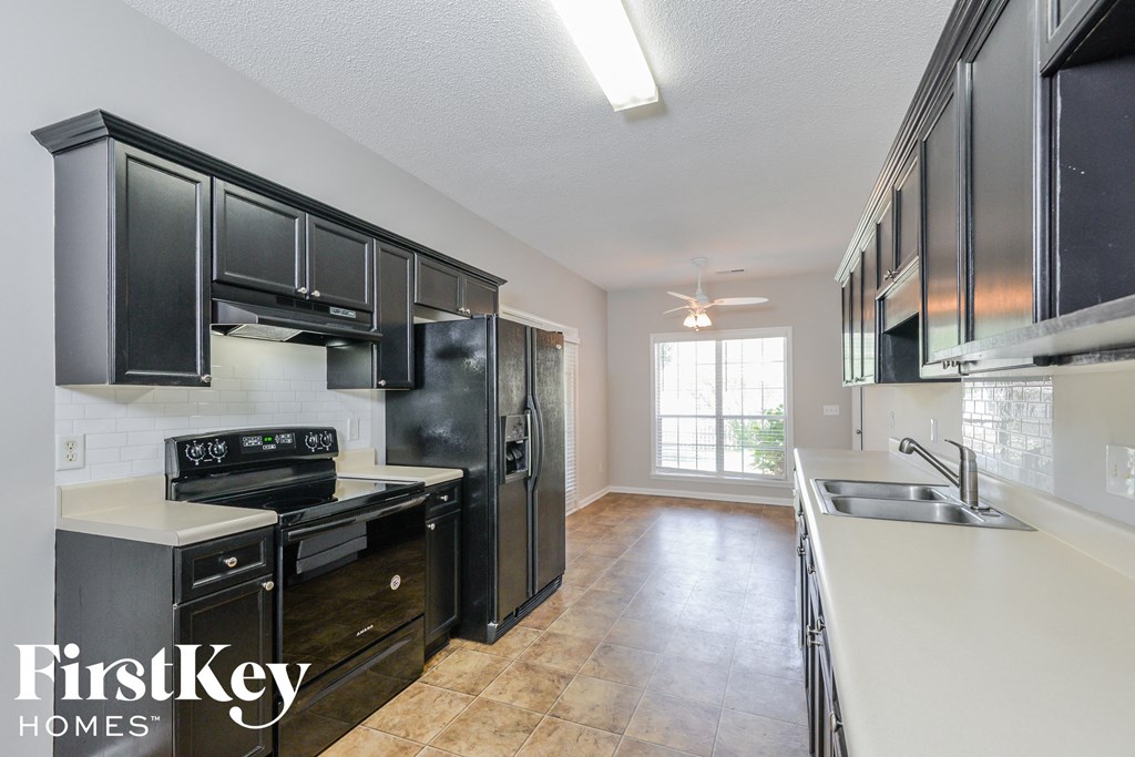 a kitchen with black appliances and white counter tops and black cabinets