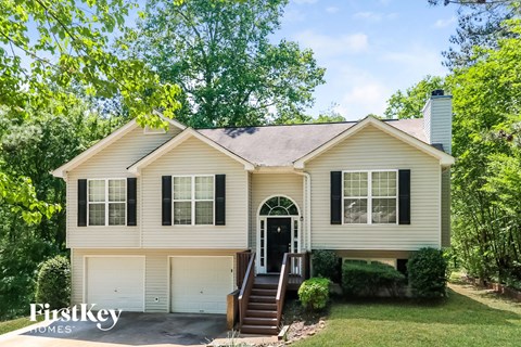 the front of a white house with black shutters