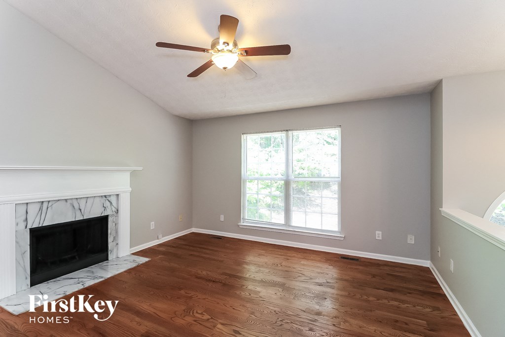 a living room with a fireplace and a ceiling fan