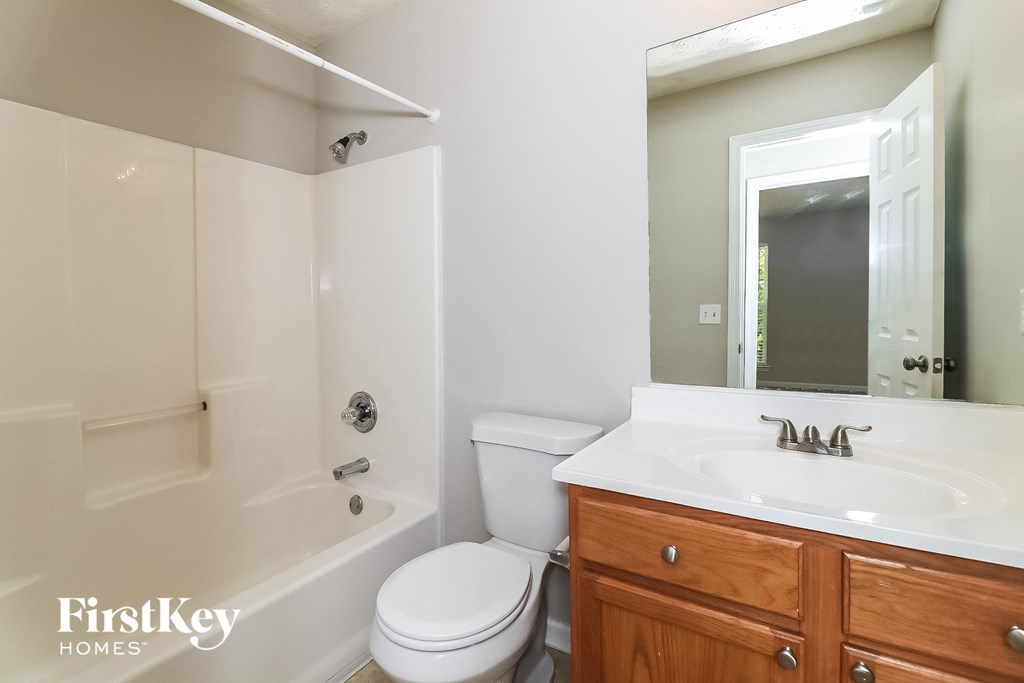 a bathroom with a sink toilet and tub and a mirror