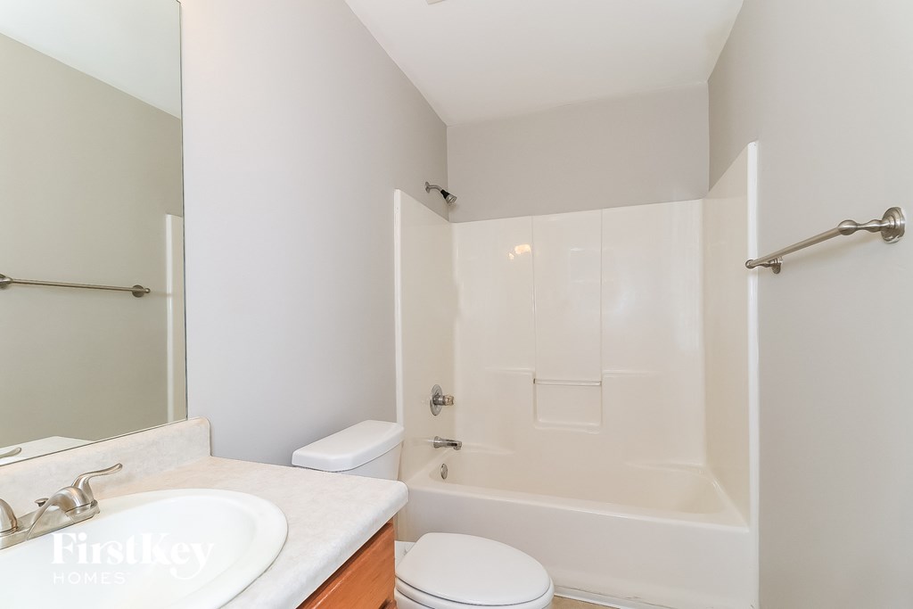 a bathroom with a shower toilet and sink and a mirror