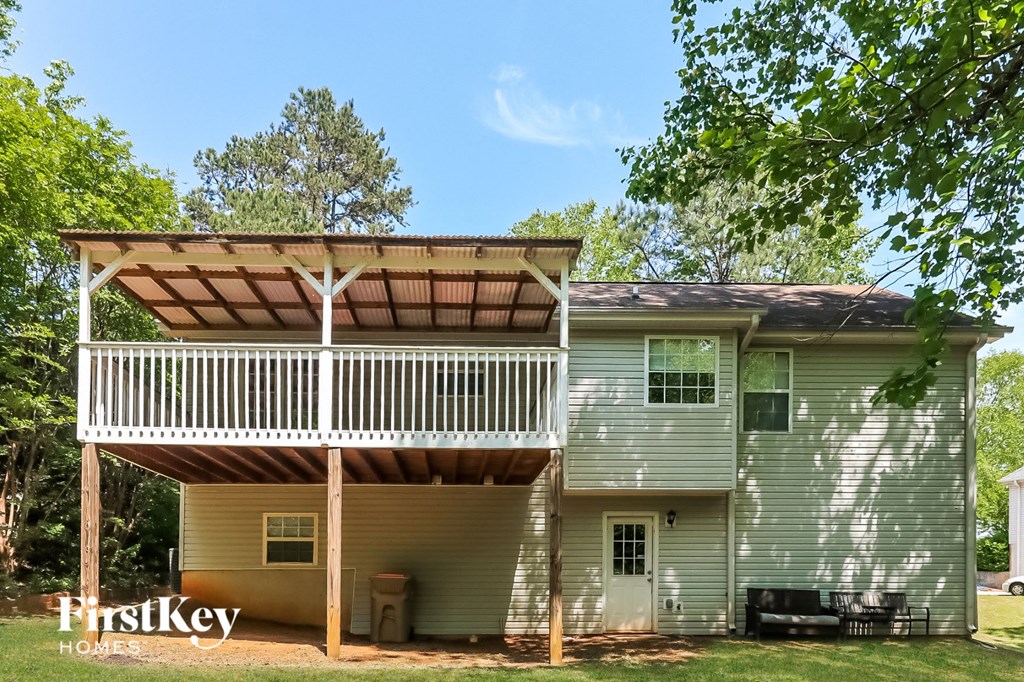 the back of the house with a deck and a pergola