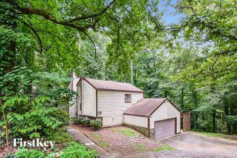 two sheds in a wooded area with trees
