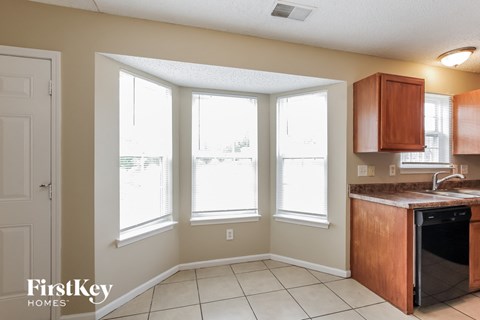 a kitchen with a sink and three windows