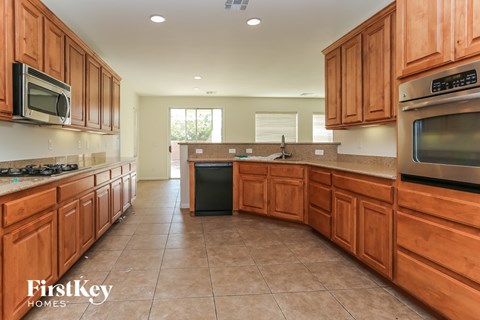A kitchen with wooden cabinets and a tiled floor.