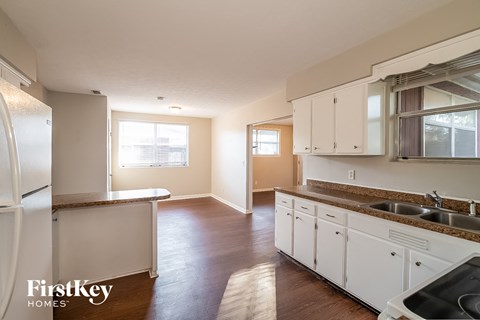 A kitchen with white cabinets and a refrigerator.
