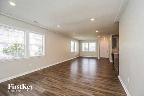 A spacious room with wooden floors and a white door.
