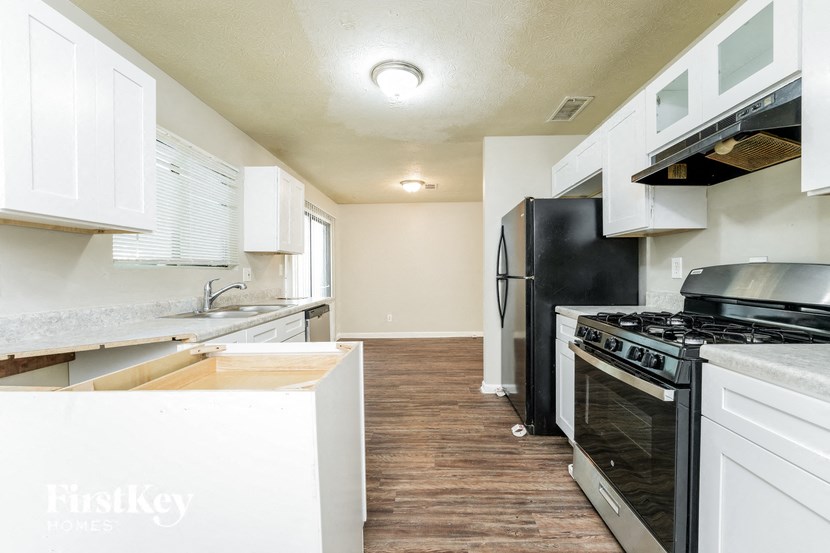 a renovated kitchen with white cabinets and black appliances