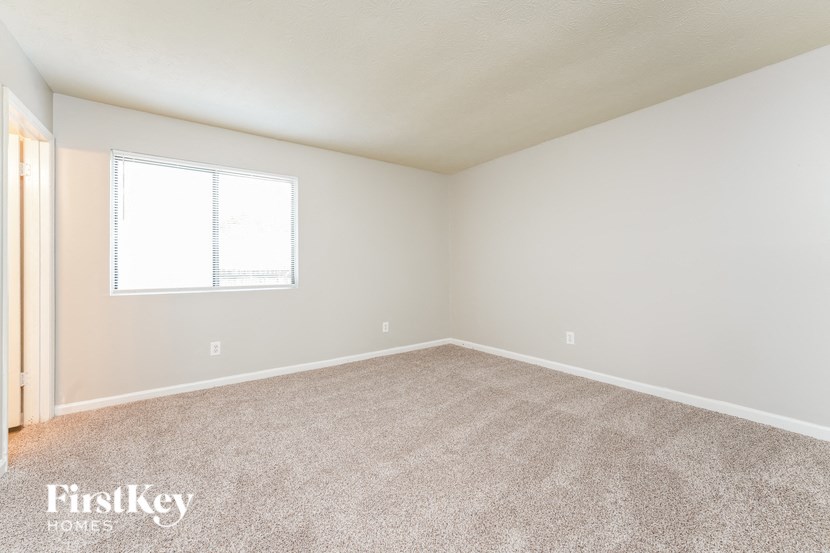 a empty room with carpet and a window