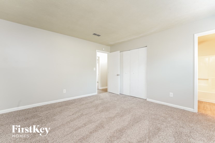a spacious living room with carpet and white walls