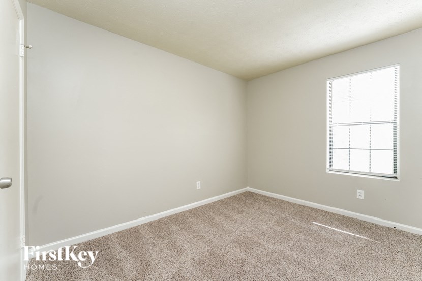 an empty room with carpet and a window