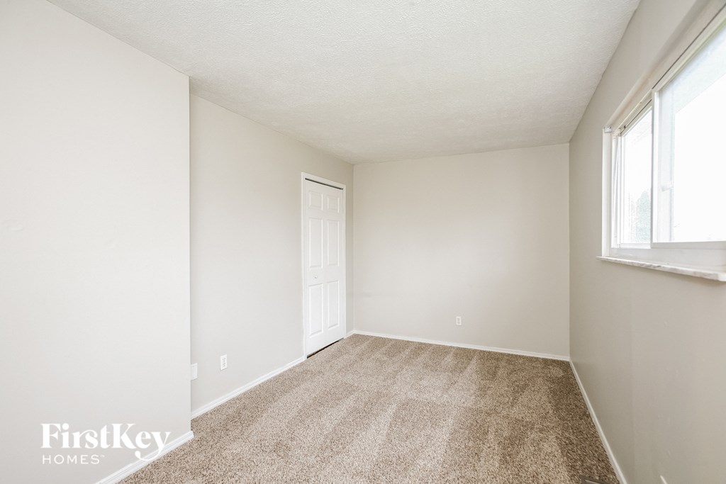 A room with a carpeted floor and a door.