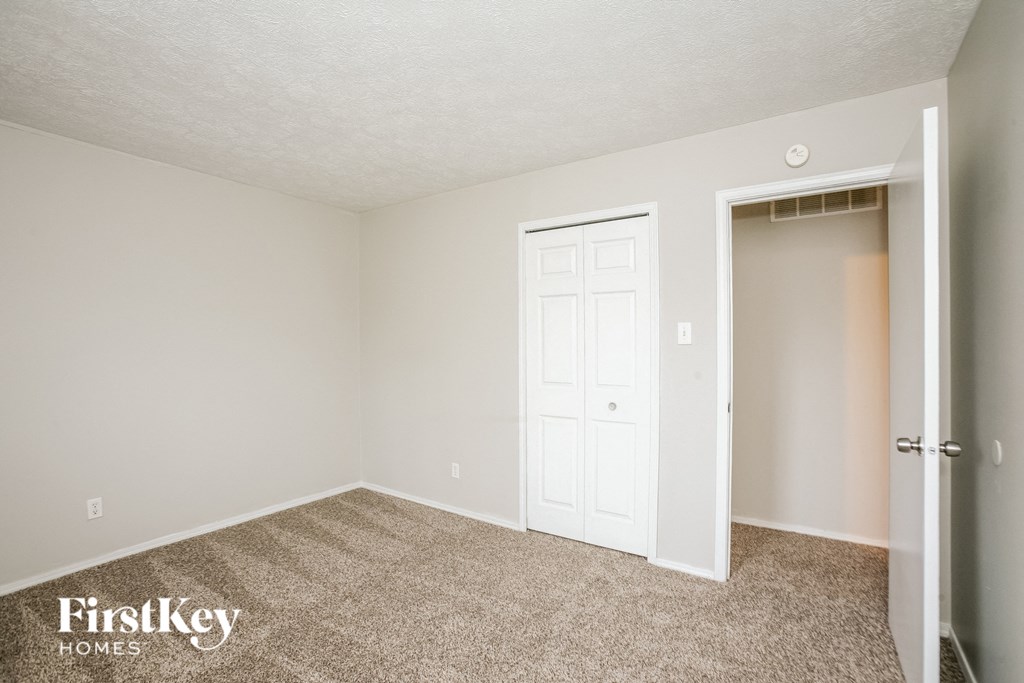 A room with a carpeted floor and a white door.
