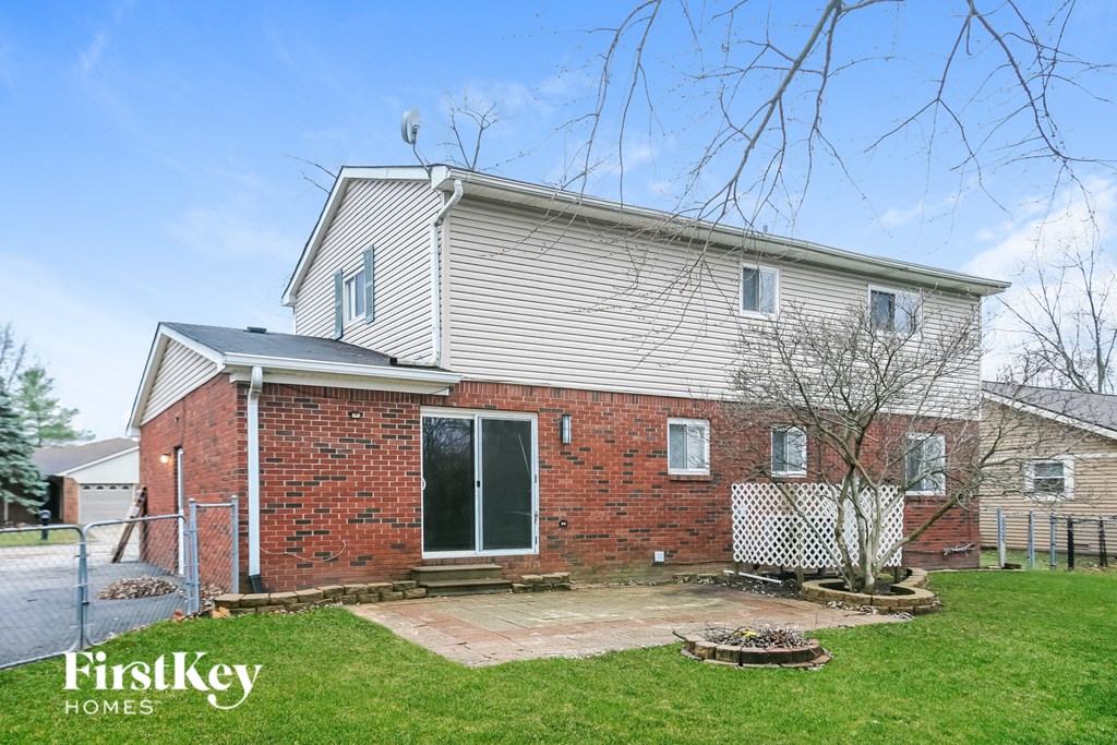 A brick house with a tree in front of it.