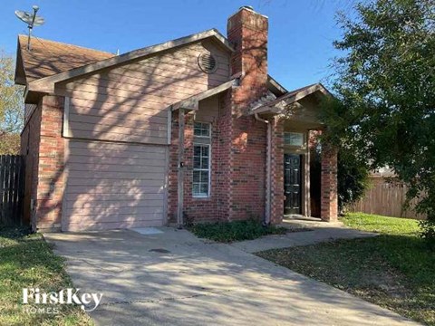 a small brick house with a sidewalk in front of it