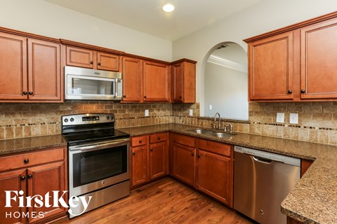 A kitchen with wooden cabinets and a stainless steel dishwasher.