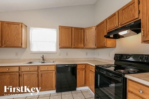 A kitchen with wooden cabinets and black appliances.