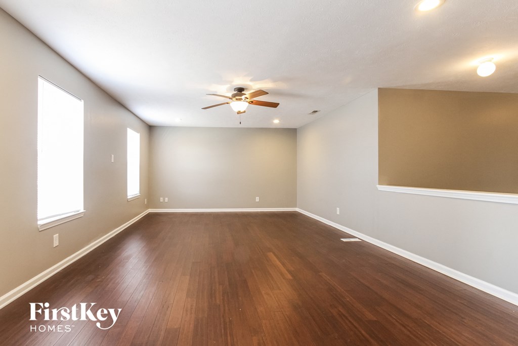 A room with wooden floors and a ceiling fan.