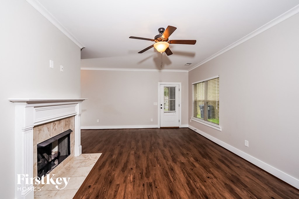 a living room with a fireplace and a ceiling fan
