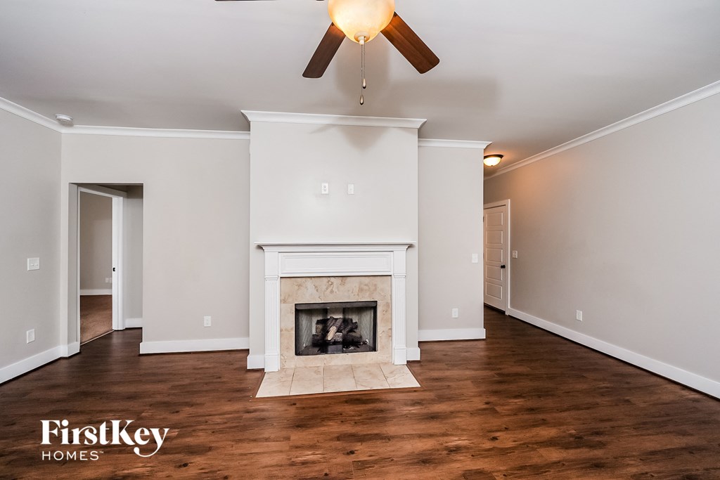 a living room with a fireplace and a ceiling fan