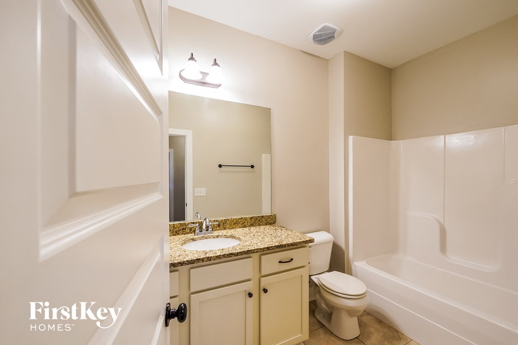 a bathroom with a toilet and a sink and a mirror