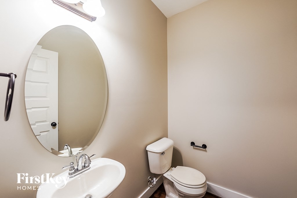 a bathroom with a toilet and a sink and a mirror