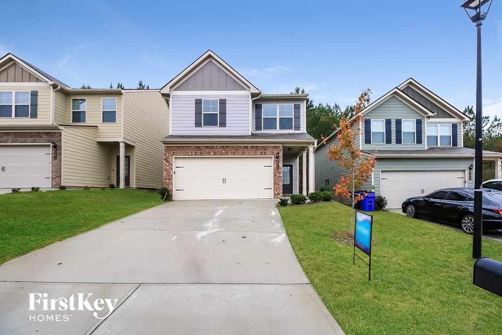 two story home with two garage doors and a driveway