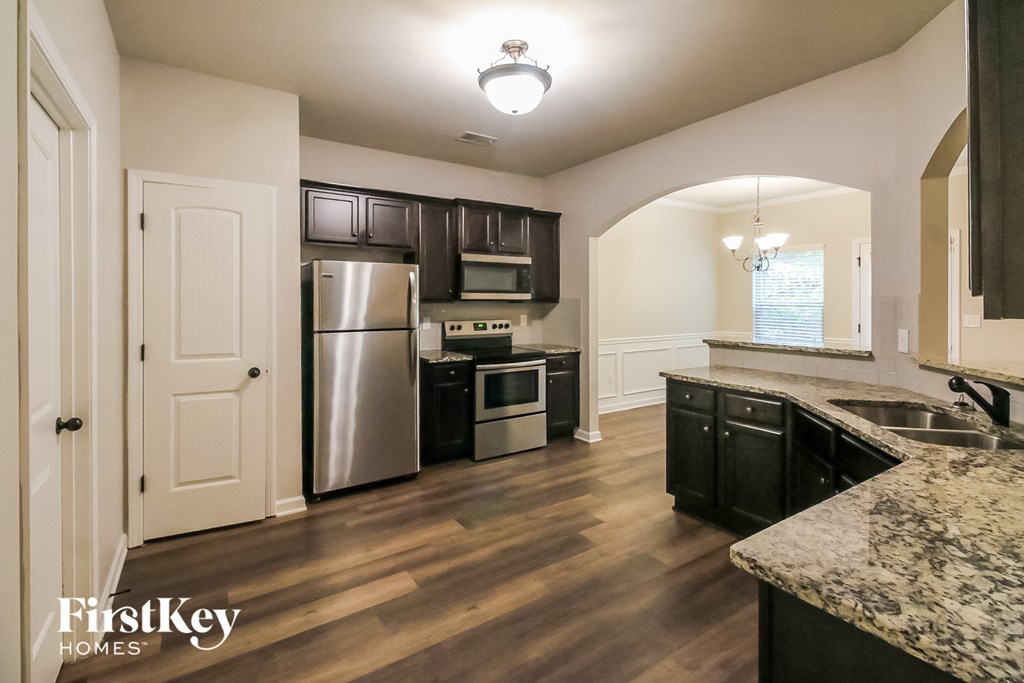 a kitchen with black cabinets and stainless steel appliances
