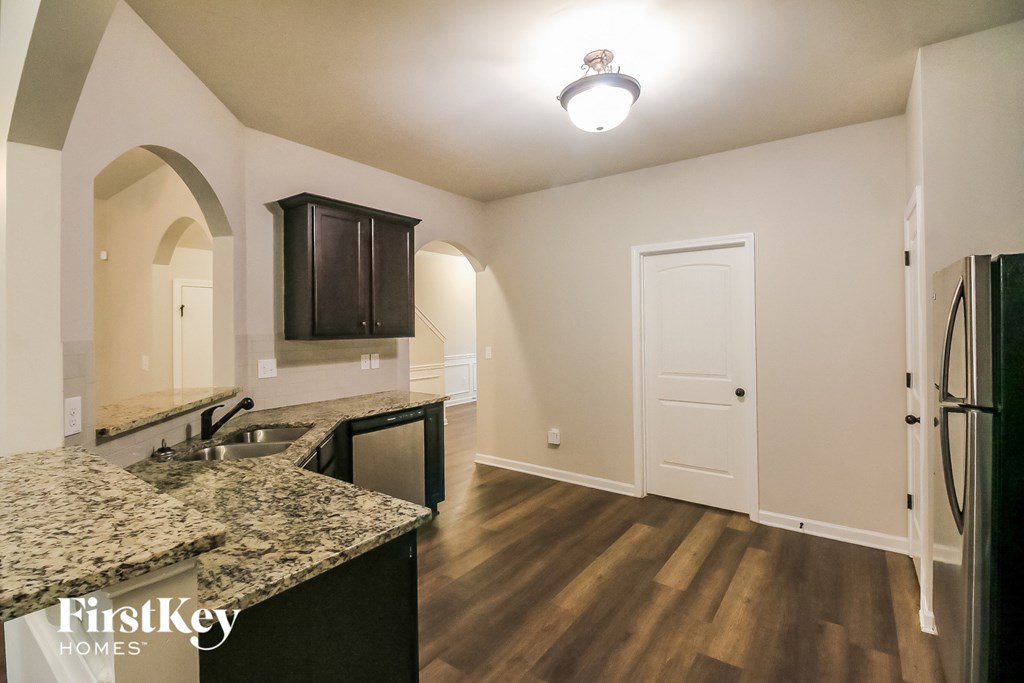 a kitchen with granite counter tops and a stainless steel refrigerator